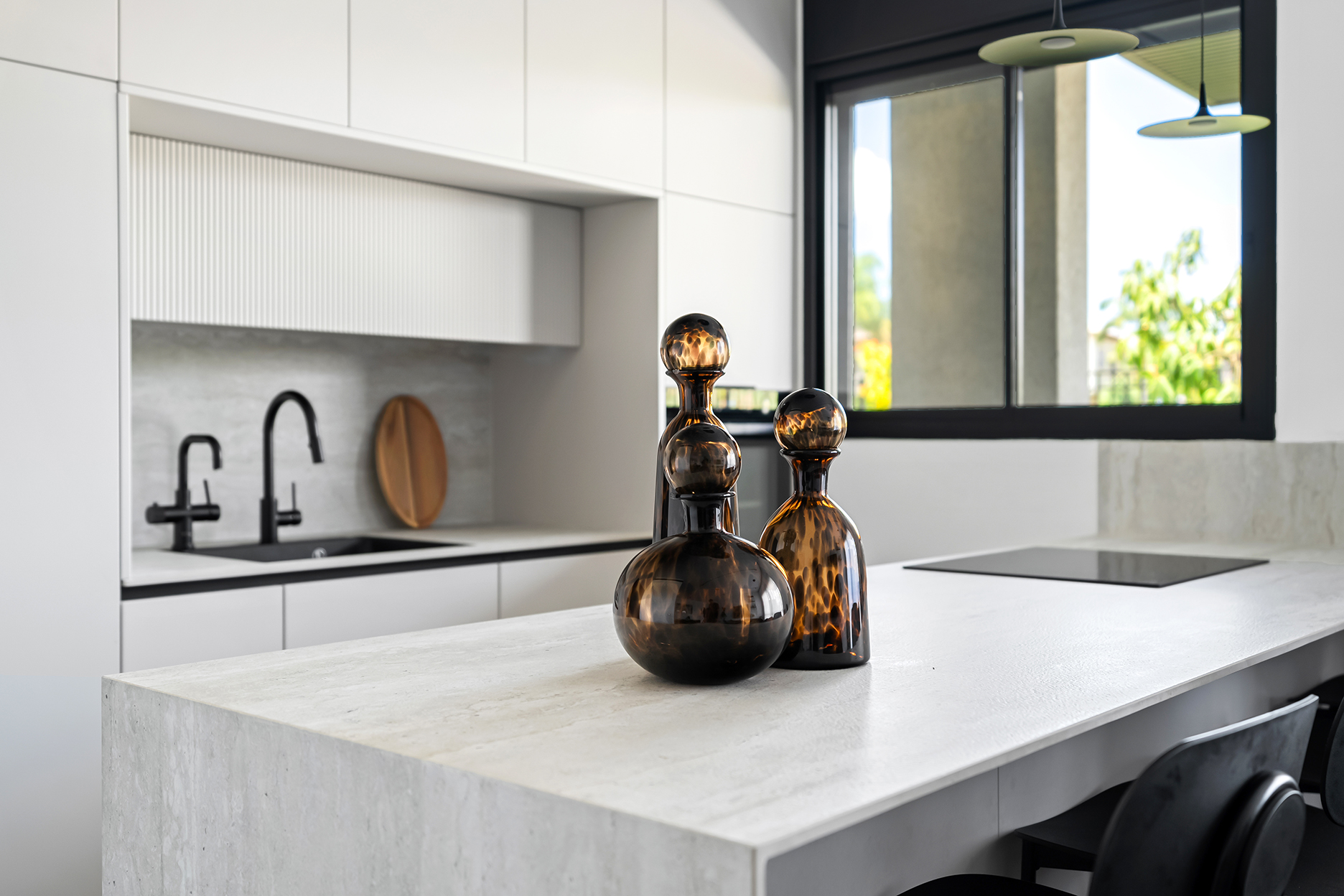 תקריב על משטח שיש לבן במטבח מודרני עם כיור וברז שחור - נגרות האומנות שבמטבח